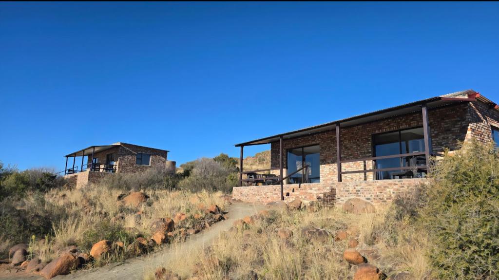 a house on the side of a hill at Izinga Game Karoo Guest Farm in Philipstown