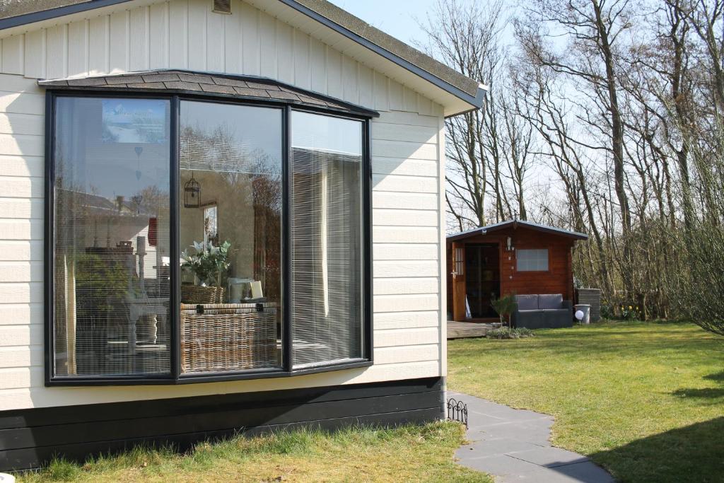 una casa con una grande finestra sul lato di Weideveld 60 Michelle a Den Burg