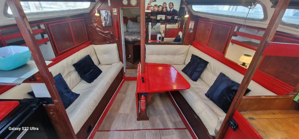 Un pequeño barco con una mesa roja en el medio. en Grand voilier avec tout confort, en Cherbourg-en-Cotentin