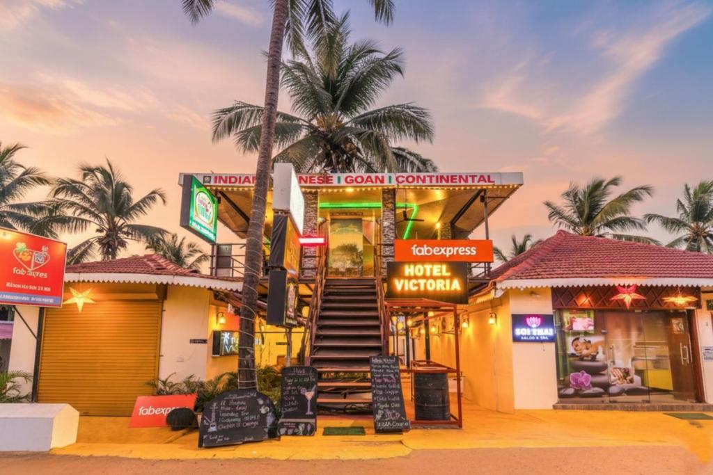 Un edificio con palmeras y carteles. en Via Victoria With Pool - Nr Baga Beach, en Baga