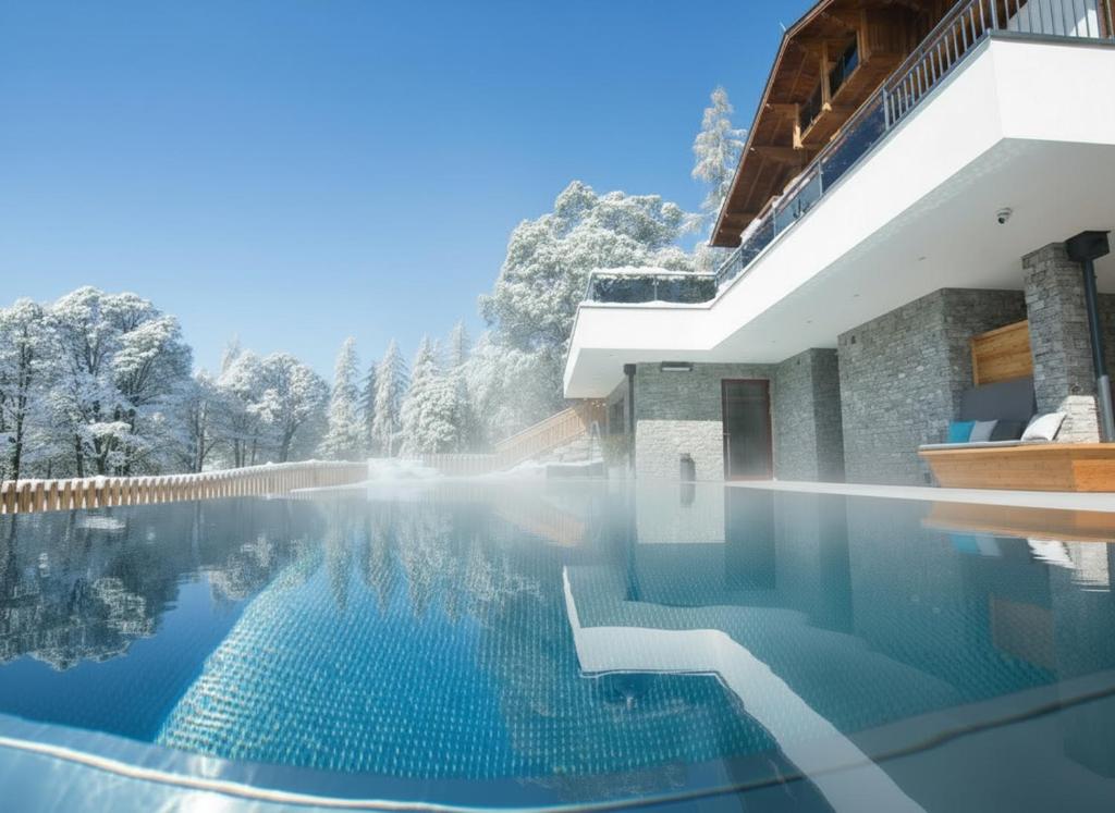 uma piscina em uma casa com árvores ao fundo em Hotel Rösslhof em Ramsau am Dachstein