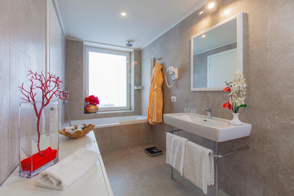 a bathroom with a sink and a mirror at Hotel Caparena in Taormina