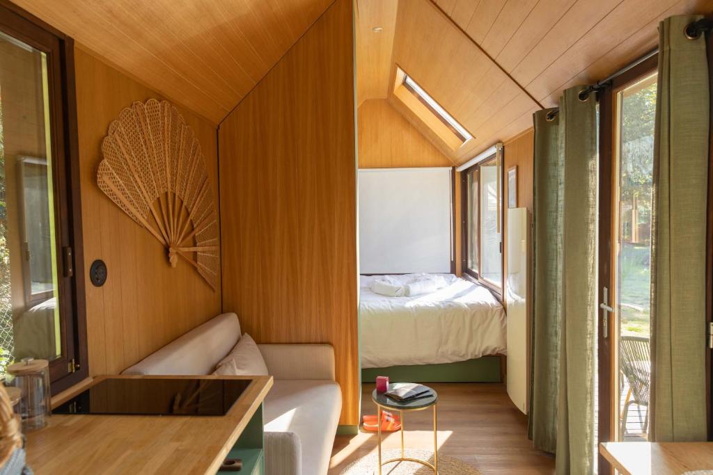 En eller flere senge i et værelse på Tiny houses PAMPA Lodges - étang & bain nordique