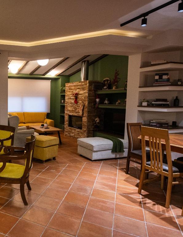 a living room with a fireplace and a table and chairs at Silyvo Cottage in Tríkala