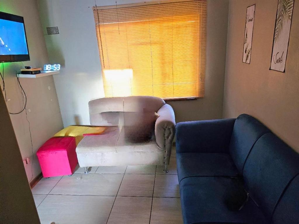 a living room with a couch and a tv at Waterworks Overnights in Kimberley