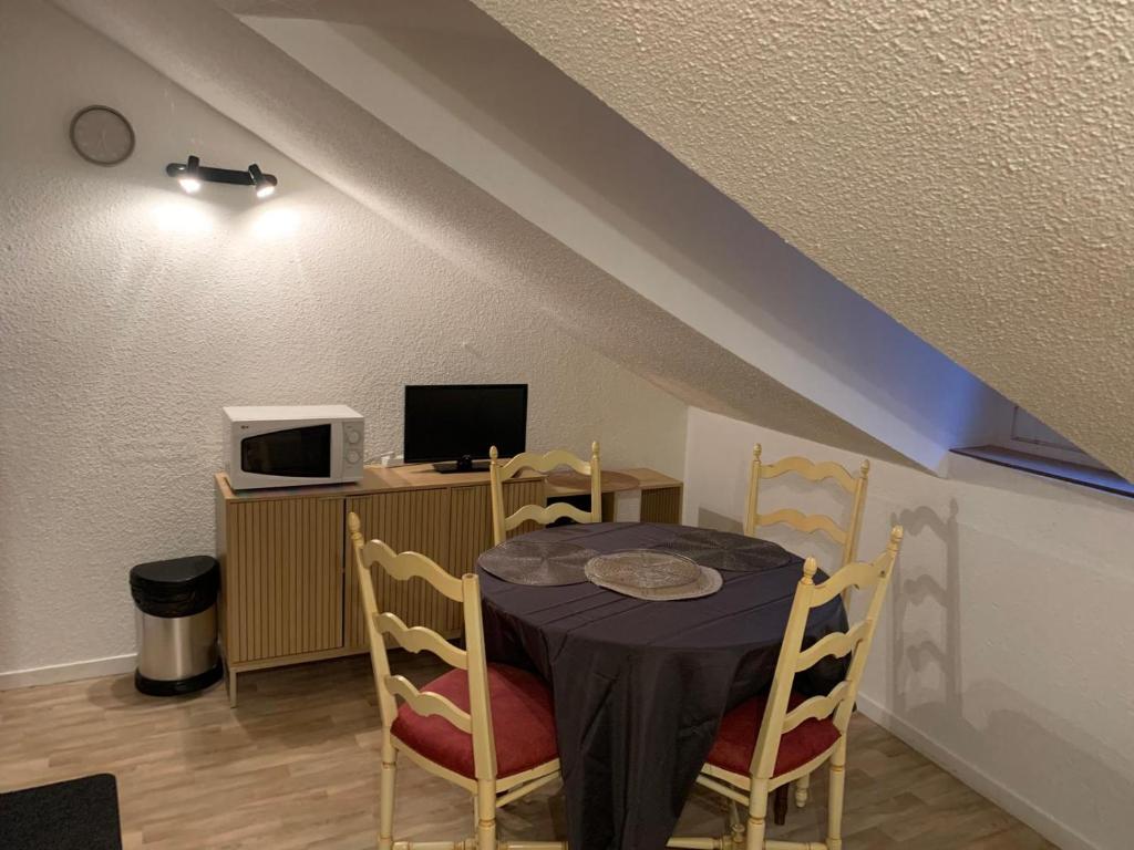 una sala da pranzo con tavolo, sedie e computer di Le grand duc17 a Cauterets