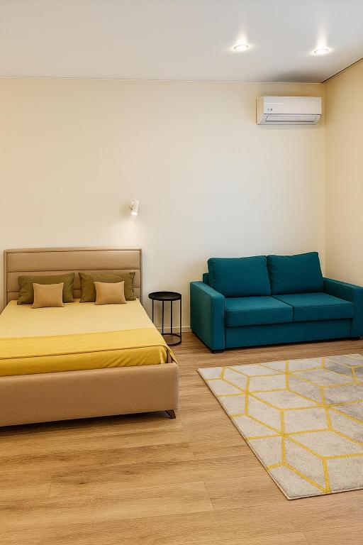 a bedroom with a bed and a couch at Kolsay in Kirovo