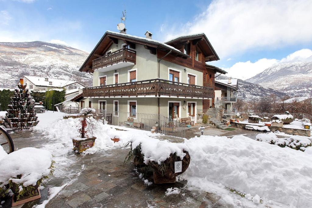 ein Haus mit Schnee auf dem Boden davor in der Unterkunft Au Petit Chevrot - Garden in Aosta