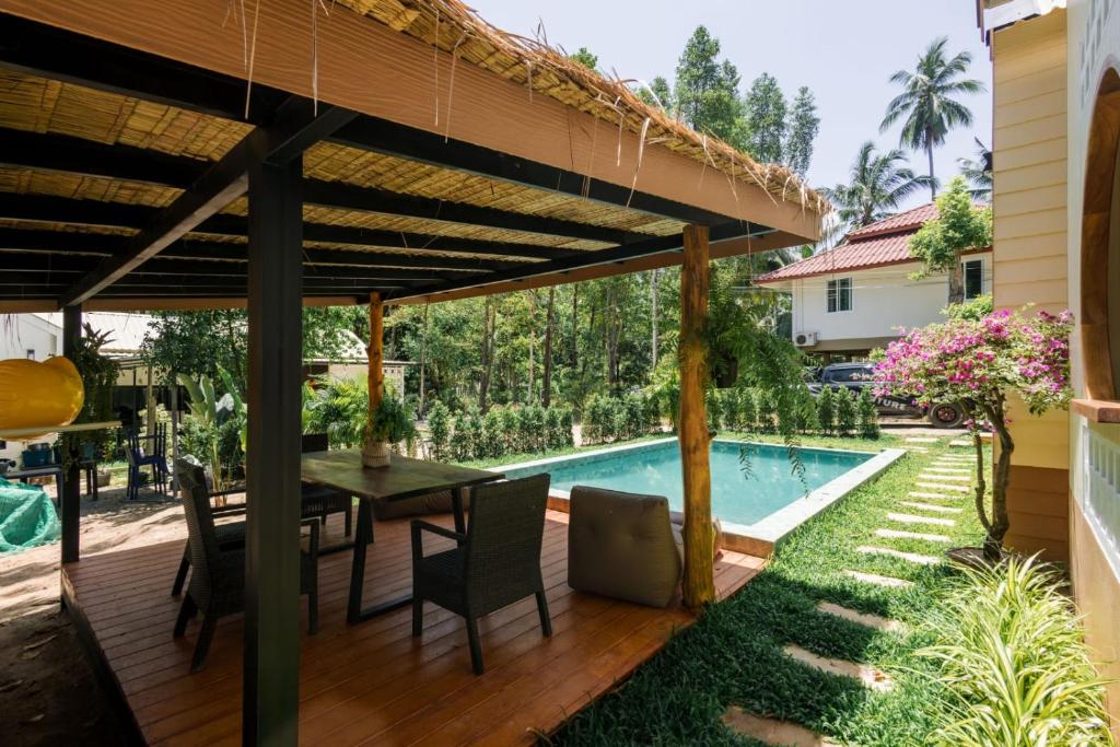 eine Terrasse mit Tisch und Swimmingpool in der Unterkunft Villa Casa Blanca in Ban Madua Wan
