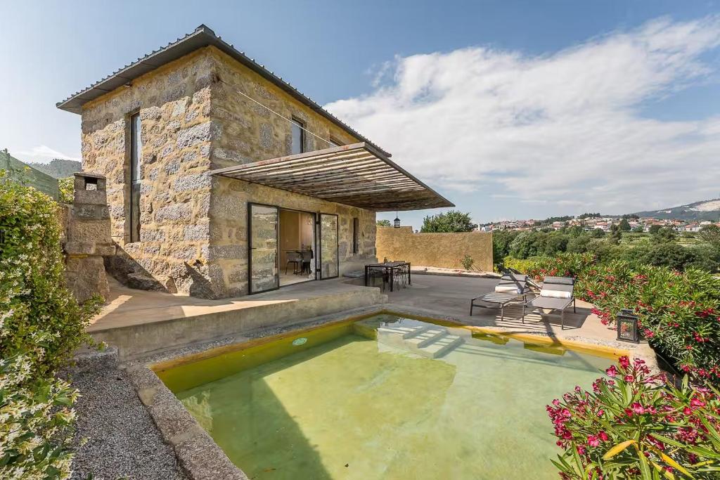 a stone house with a pool in front of it at Romantic Lemon Grove Cottage with Private Pool - Oporto Lemon Farm, near Porto in Valpedre