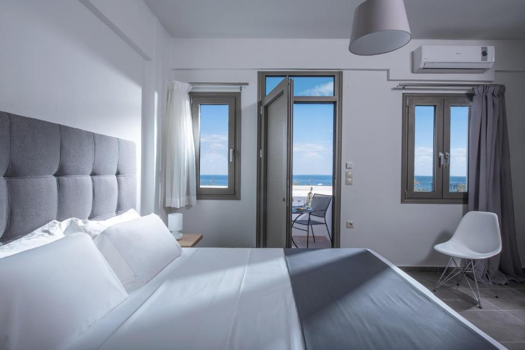 una camera da letto con un letto grande con vista sull'oceano di Bianca Doma Adults Only by Estia a Hersonissos