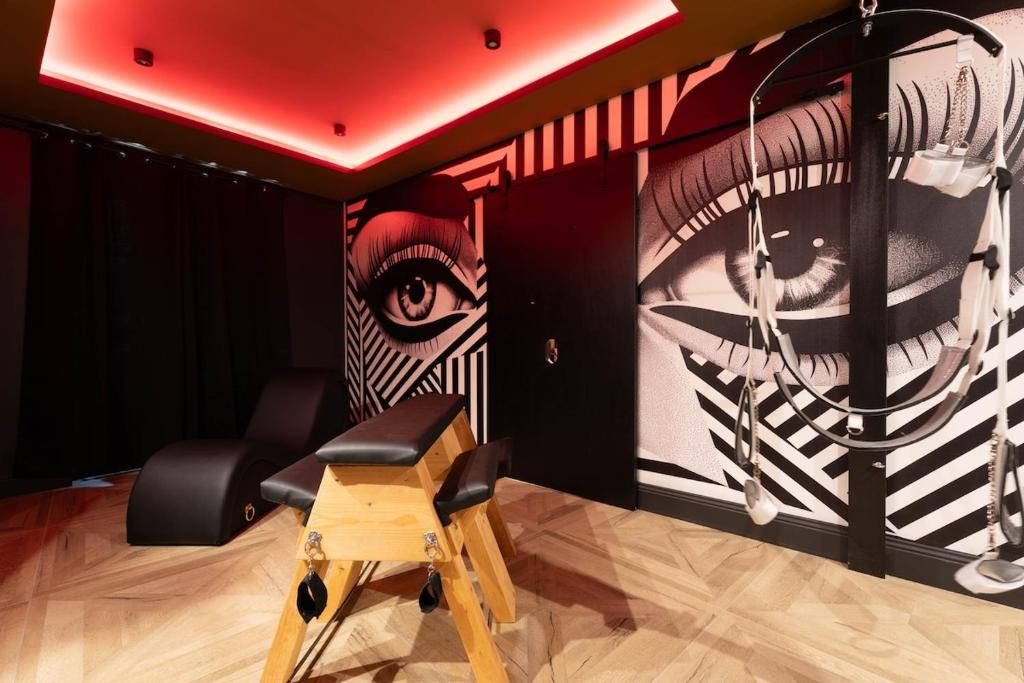 a room with a painting of an eye on the wall at loveroom le donjon in Anse