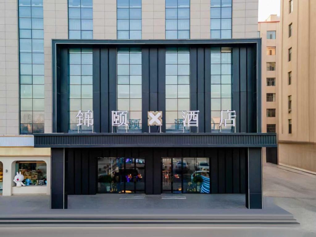 a building with chairs in the front of it at Jin Yi X Hotel in Hekou