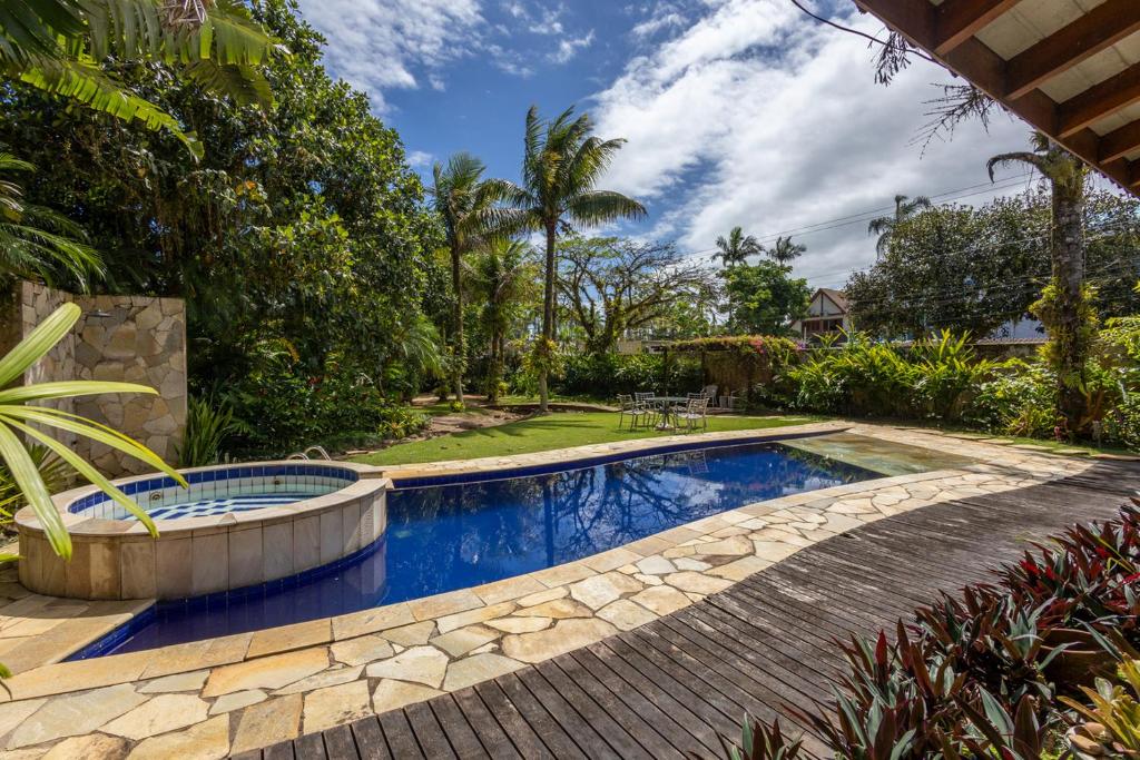 巴拉尤娜Casa Alto Padrao com 5 Suites e Jacuzzi Privativa的后院的游泳池,周围设有石头人行道