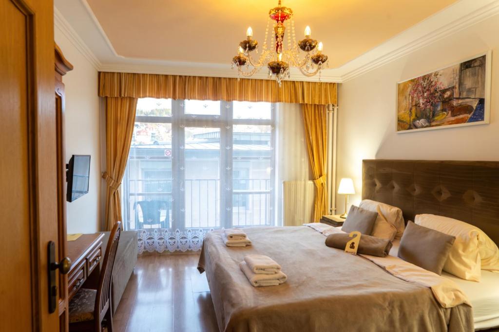 a bedroom with a large bed with a large window at LD Morava in Karlovy Vary