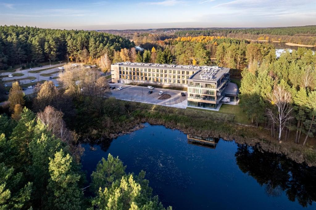 eine Luftaufnahme eines Gebäudes neben einem See in der Unterkunft Vidok Apartamenty, Sun & Snow in Olsztyn
