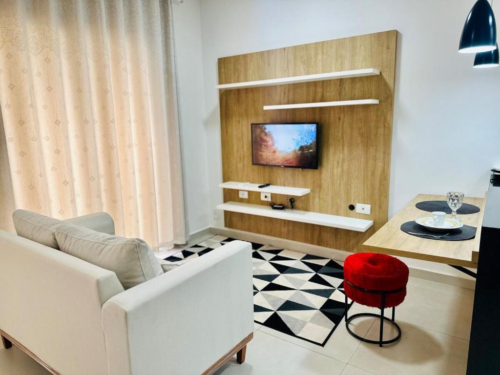 Super Loft 4 في ساو جوزيه دو ريو بريتو: غرفة معيشة مع أريكة بيضاء وكرسي احمر