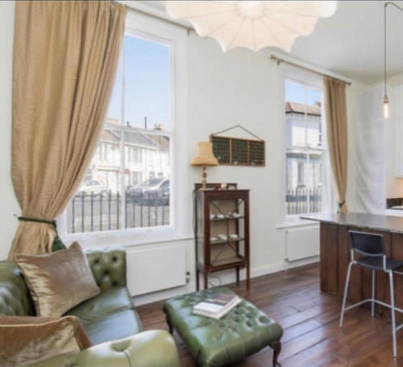 un salon avec un canapé et deux fenêtres dans l'établissement Park Crescent Brighton, à Brighton et Hove