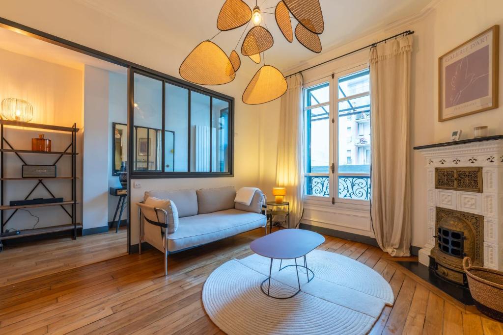 een woonkamer met een bank en een open haard bij Maison Gabrielle - Welkeys in Charenton-le-Pont