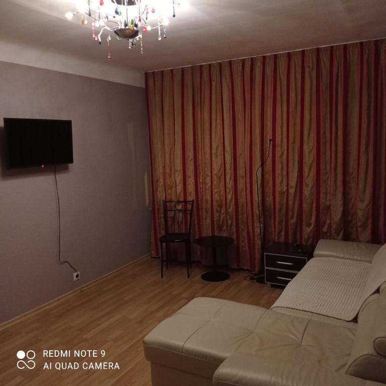 a living room with a couch and a tv at Vienības 28 in Daugavpils
