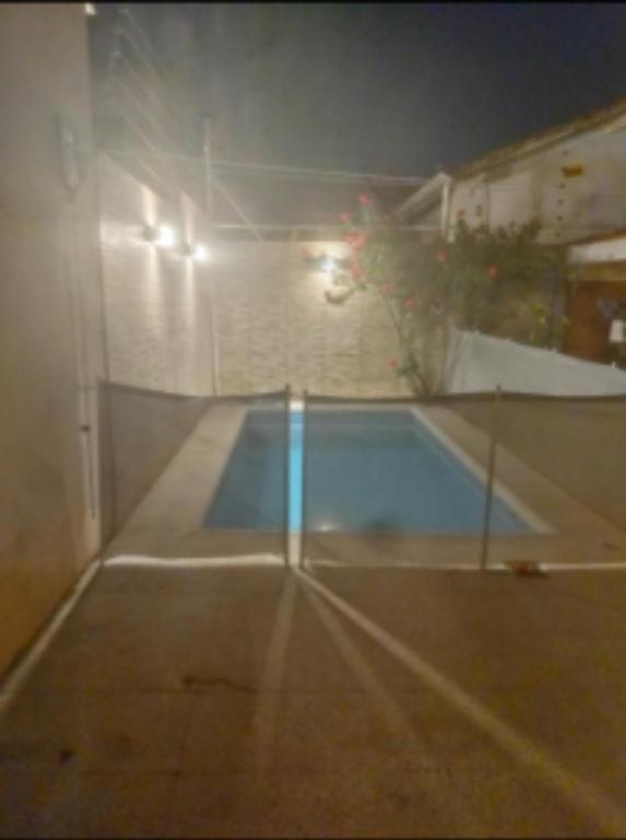 Casa Chauvin con pileta في مار ديل بلاتا: مسبح فارغ في الليل مع انارة