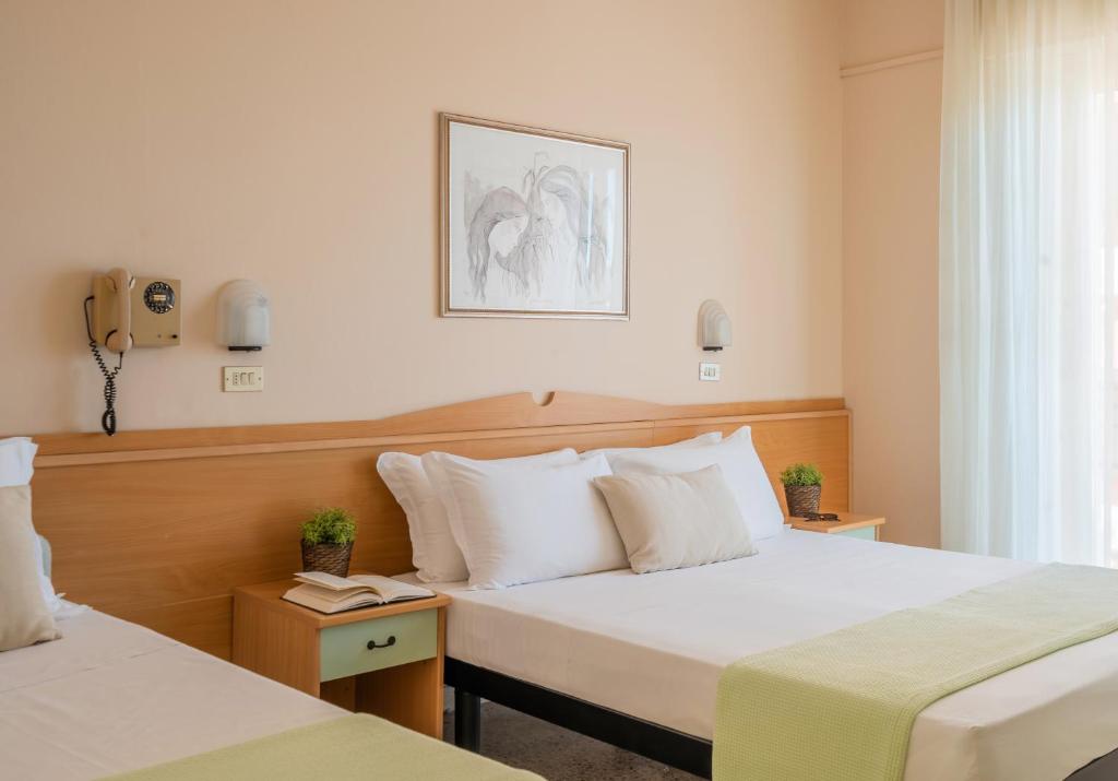 ein Hotelzimmer mit zwei Betten und einem Fenster in der Unterkunft Milano Simple in Bellaria-Igea Marina