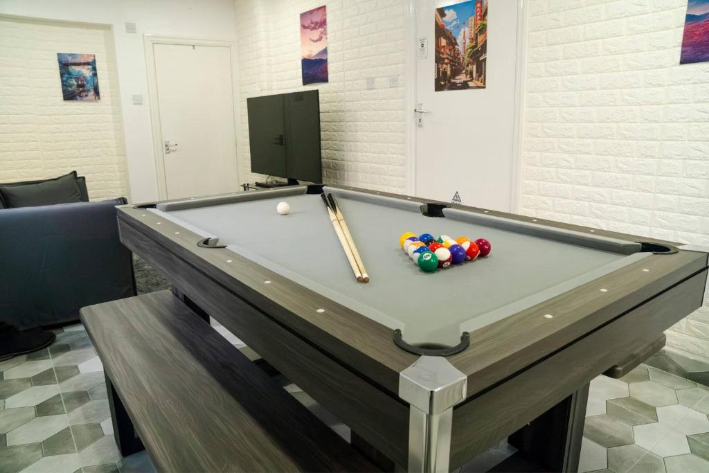 a pool table with a cue and balls on it at Modern 4-Bed Retreat in Prestwich, Perfect for Weekend Getaways in Manchester