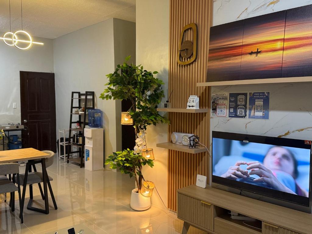 uma sala de estar com uma grande televisão e uma mesa em Kamayo Guest House -near Dahican beach em Dahikan