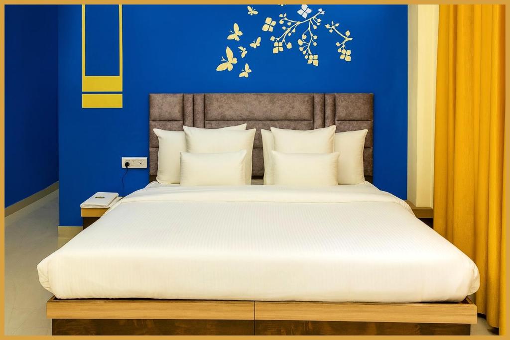 a bedroom with a large bed with a blue wall at Mahakal Road The Shikhar #Avenue Residency Near Ujjain Junction Railway Station 500m-Mahakaleshwar Jyotirlinga - Free Wifi and Lift Facilities # Air Conditioning Rooms - Best Premium Hotel In Ujjain in Ujjain