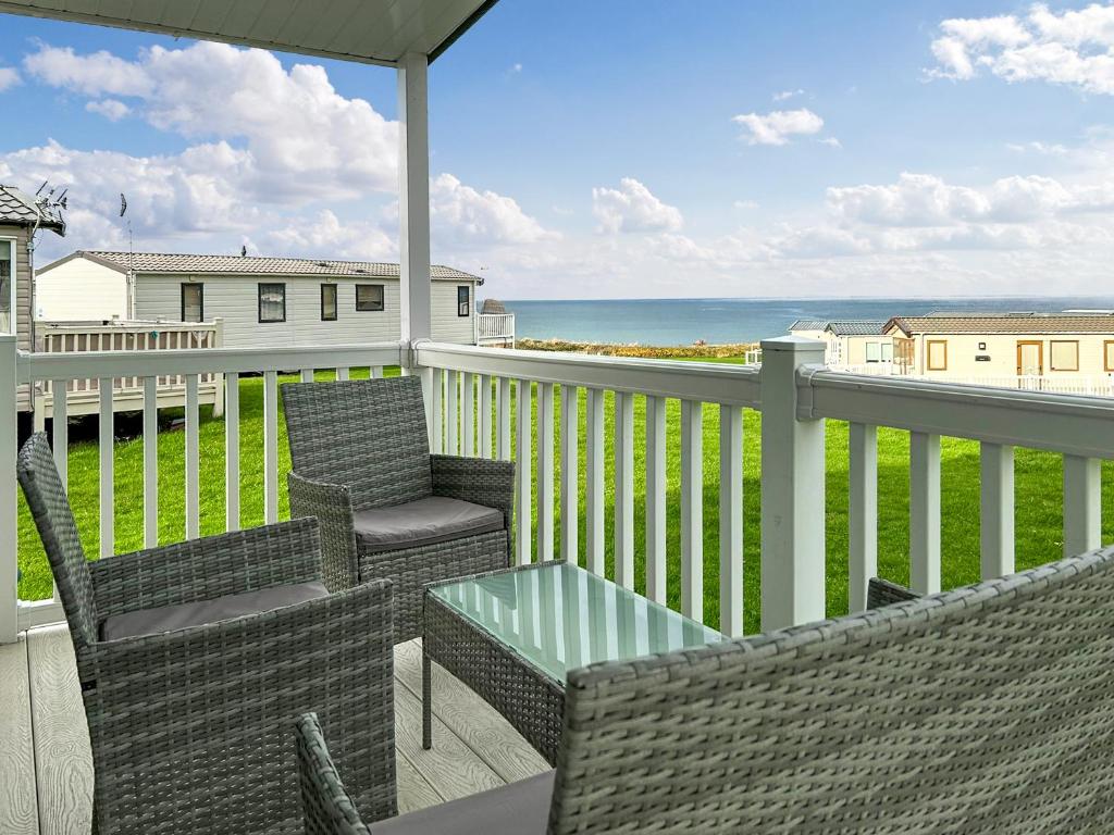 balcone con sedie, tavolo e vista sull'oceano di Ocean Bay View - Ukc7143 ad Ayr