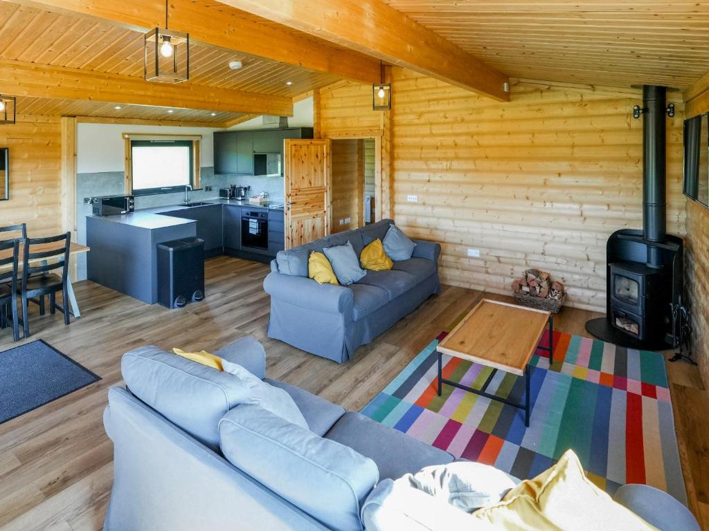 Una sala de estar con un sofá y una estufa. en Primrose Lodge - Uk50874, en Hittisleigh