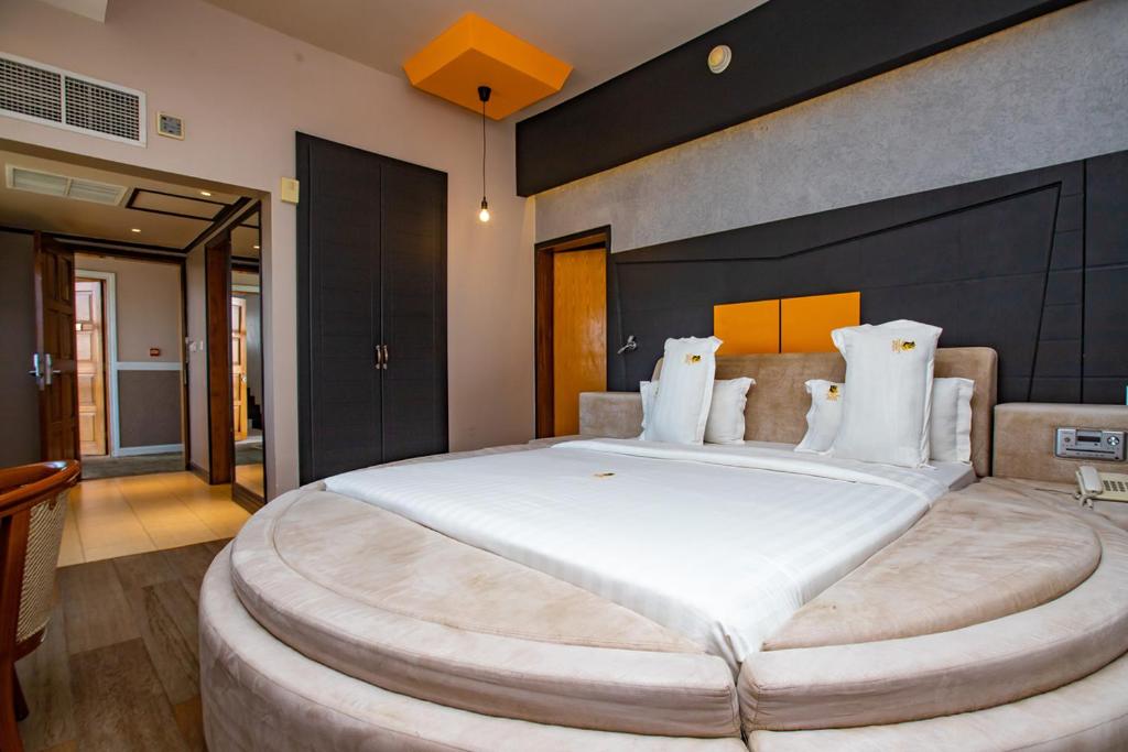 姆万扎金冠酒店的大卧室配有一张带白色枕头的大床