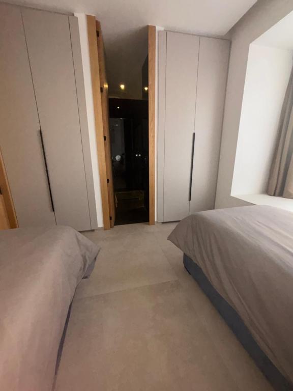 a bedroom with two beds and a door to a bathroom at Villa 5 suites piscine privée in Marrakesh