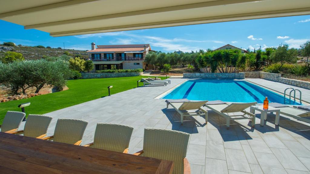 a patio with chairs and a swimming pool at Villa Mathea in Kounoupidhianá