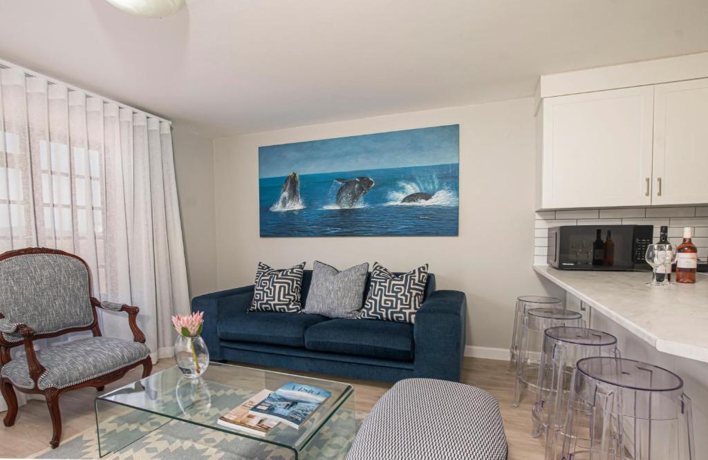 a living room with a blue couch and a kitchen at A Whale of a Time Knysna in Knysna