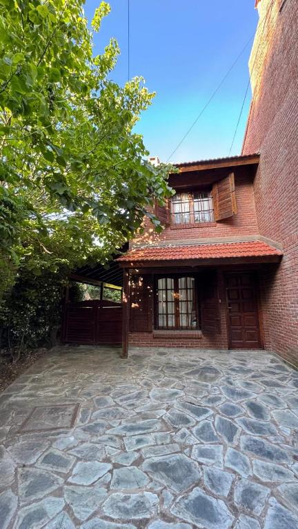 a brick house with a stone patio in front of it at Casa Calamar I in Valeria del Mar