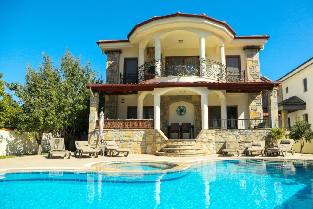 a house with a swimming pool in front of a house at Hot tub-Fireplace-Pets-Sleeps 11-Bbq-Pool-Parking in Dalyan