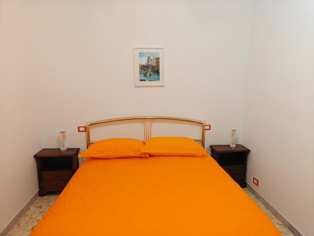 a bedroom with an orange bed with two night stands at EUR Laurentina vacation home in Rome