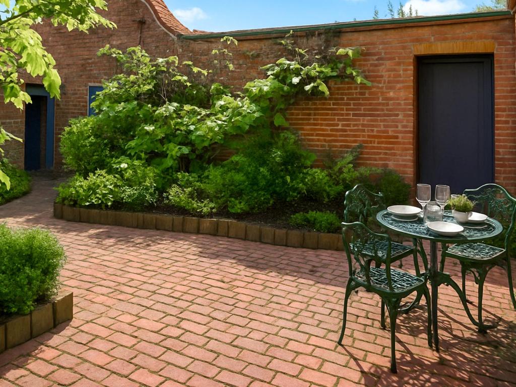 a table and chairs on a brick patio at The Coach House - Uk50884 in North Walsham
