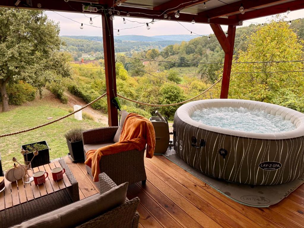 a large bath tub on a deck with a view at Offline vendégház in Orfű
