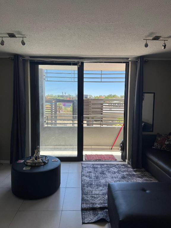 un soggiorno con un divano e una grande finestra di SkyAre Windhoek CBD a Windhoek