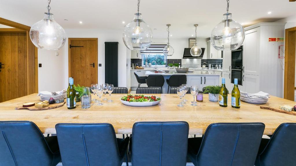 a large wooden table in a kitchen with wine bottles at Llydaw in Pwllheli