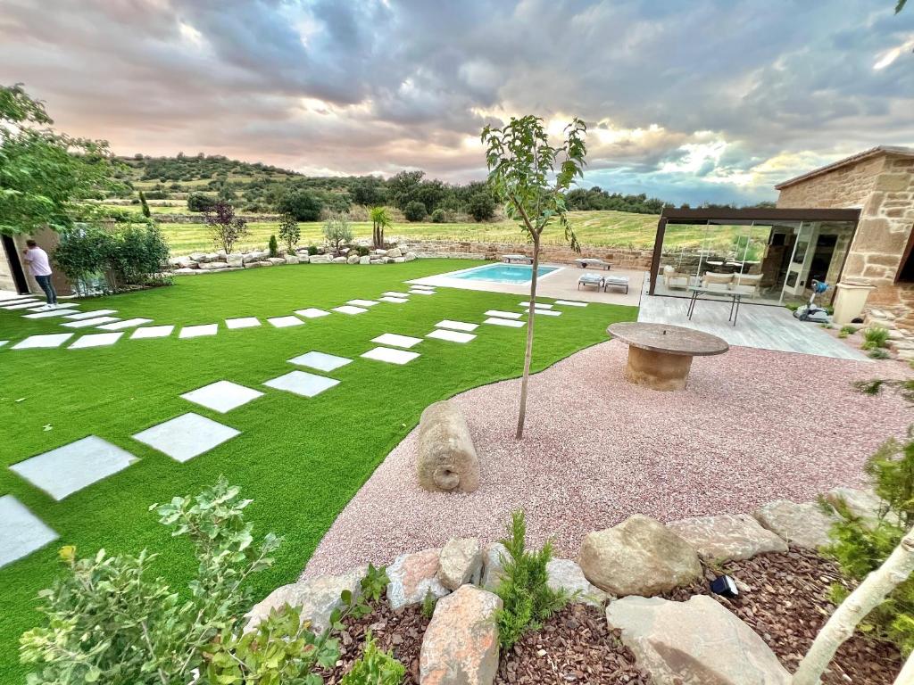 ein Garten mit einer Bank und einem Swimmingpool in der Unterkunft Natura-Resort Les Pletes in Palouet