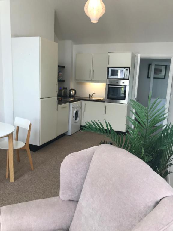 a living room with a couch and a kitchen at The Downtown Loft in Buncrana