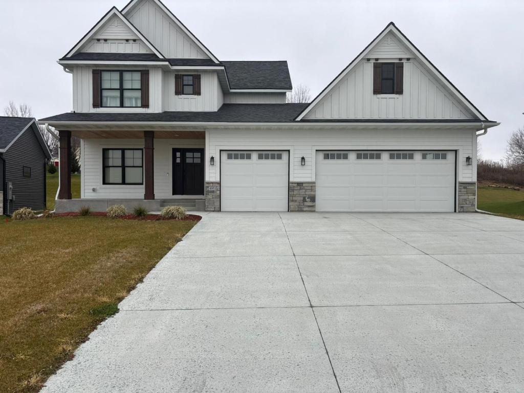 a white house with two white garage doors at Luxurious Sweet Escape stunning custom Home! in Rochester