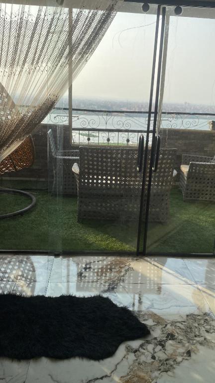 شقه مفروشه علي النيل فيو تحفه في ‘Ezbet el-Auqât: اطلالة على فناء مع كراسي ومظلة