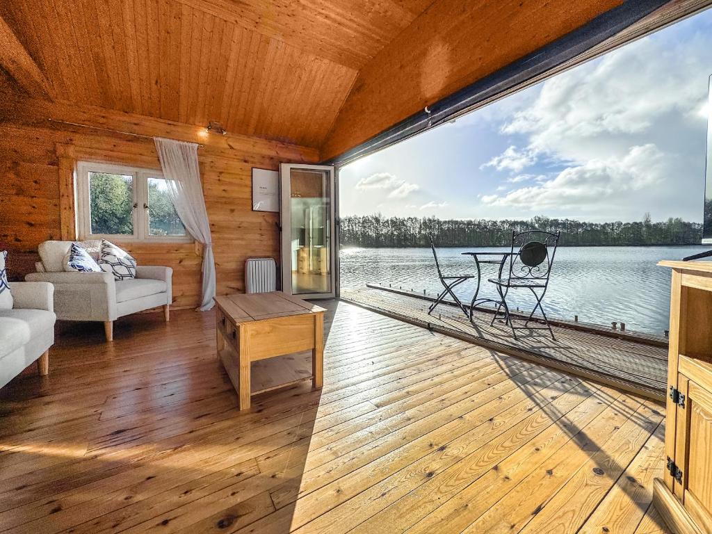 een woonkamer met uitzicht op het water bij The Boathouse - Uk50892 in Pentney