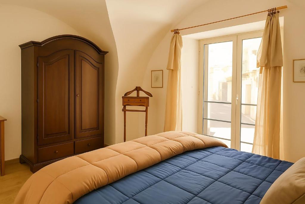 a bedroom with a blue bed and a window at Damiani Appartamenti nel Centro Storico di Palermo in Palermo