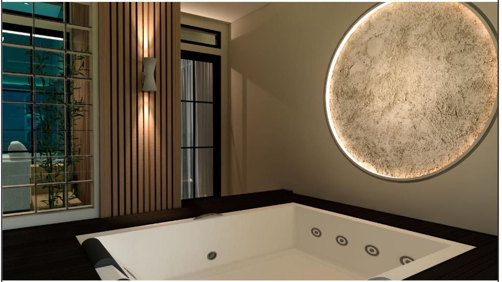 Una bañera en un baño con un espejo grande. en Lioravilla Suite Lioravilla Suite - Jacuzzi & Billiard in KBP, en Padalarang