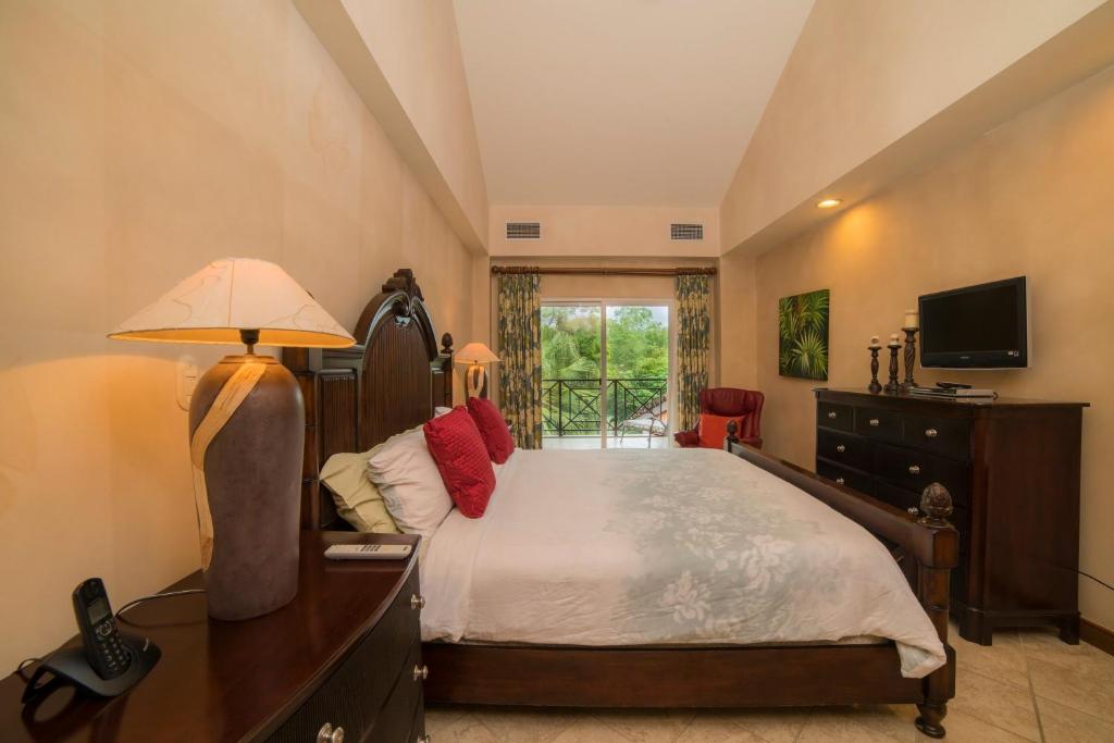 a bedroom with a bed and a desk and a television at Veranda 1B 3 bdr Golf Course View in Los Suenos in Herradura